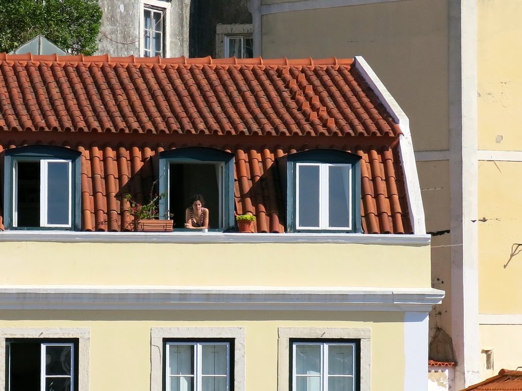 Terracotta tile roof with white dormer windows on a pale yellow house